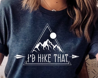 May include: A dark blue t-shirt with a white graphic of a mountain range, a moon, and an arrow with the text "I'd Hike That".