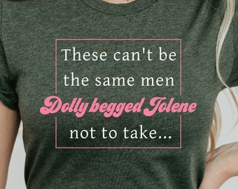 May include: A dark green t-shirt with a white box containing the text "These can't be the same men Dolly begged Jolene not to take..." in pink.