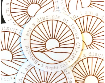 Könnte beinhalten: Ein Satz runder Aufkleber mit einem Sonnenstrahlen-Design und dem Text "Behold. I am a disciple of Jesus Christ. 3 Nephi 5:13".