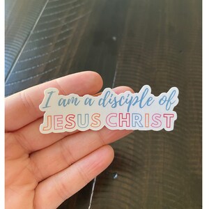 May include: A white sticker with the text "I am a disciple of JESUS CHRIST" in blue, pink, orange, and yellow lettering.