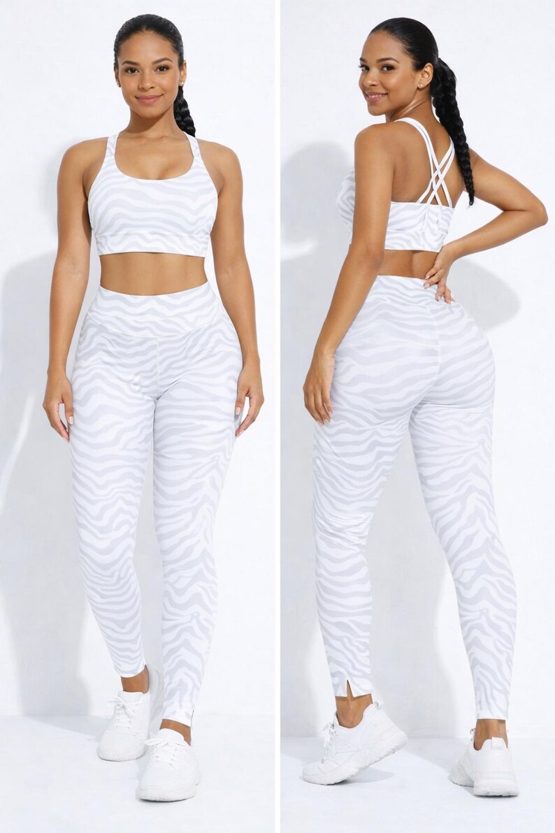 K&ouml;nnte beinhalten: Zweiteiliges Sport-Set mit wei&szlig;-grauem Zebra-Print. Das Set besteht aus einem Sport-BH und einer hoch taillierten Leggings. Das Model tr&auml;gt wei&szlig;e Turnschuhe.
