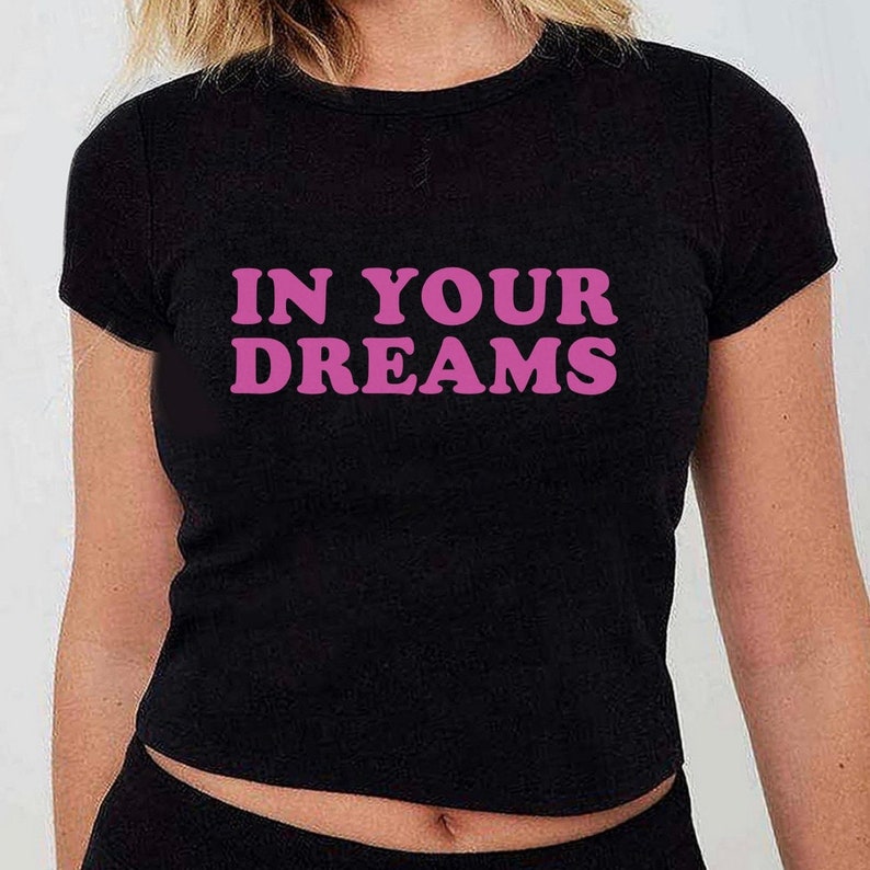 May include: Black t-shirt with the text "IN YOUR DREAMS" in pink letters.