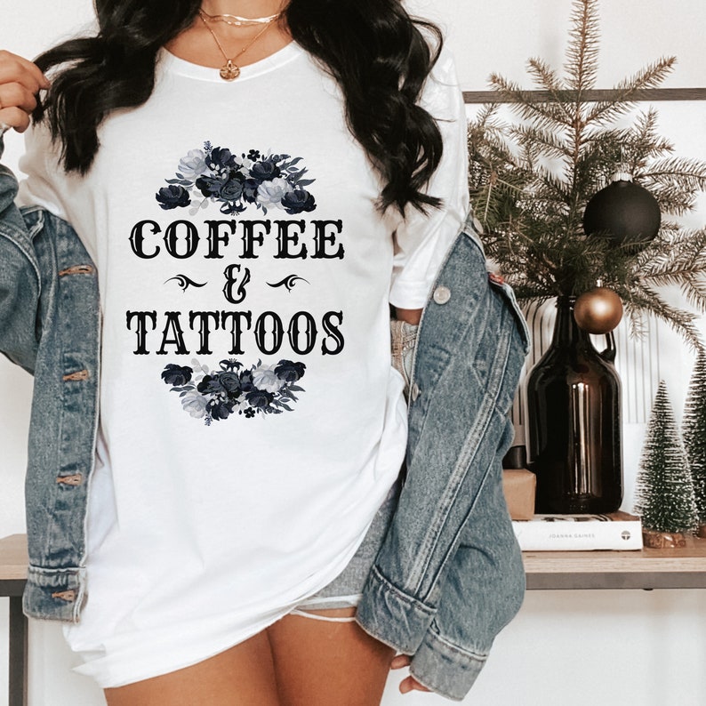 May include: White t-shirt with a black floral design and the text "COFFEE & TATTOOS".