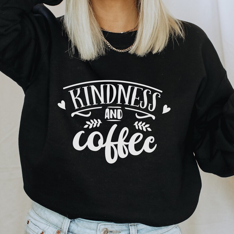 May include: Black sweatshirt with white text that reads "kindness and coffee" with a small heart on either side of the text.