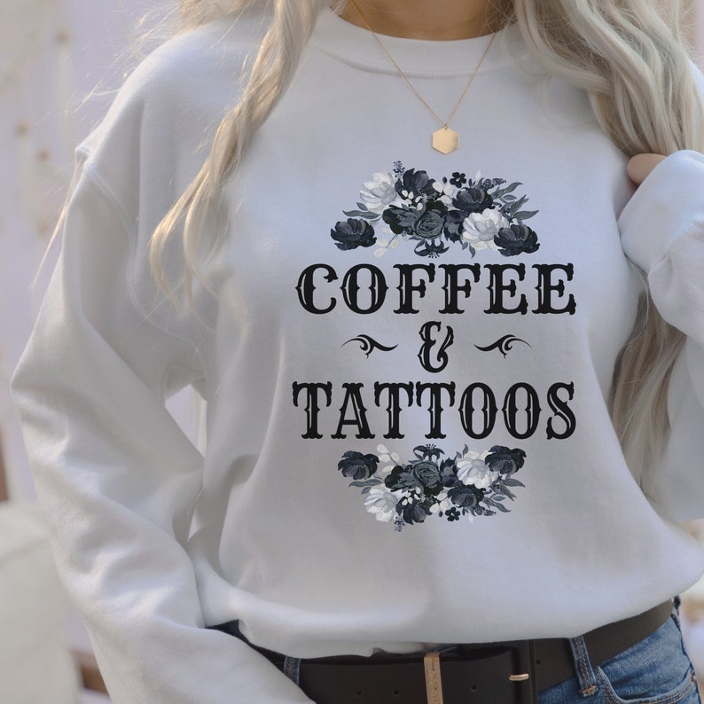 May include: White sweatshirt with a black floral design and the text "COFFEE & TATTOOS" in a vintage font.