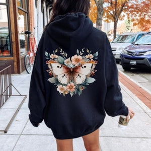 May include: Black hooded sweatshirt with a floral design featuring a butterfly on the back.