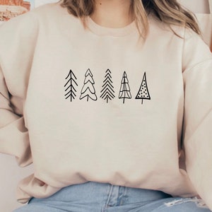 May include: A cream-colored sweatshirt with a black graphic of six stylized Christmas trees.