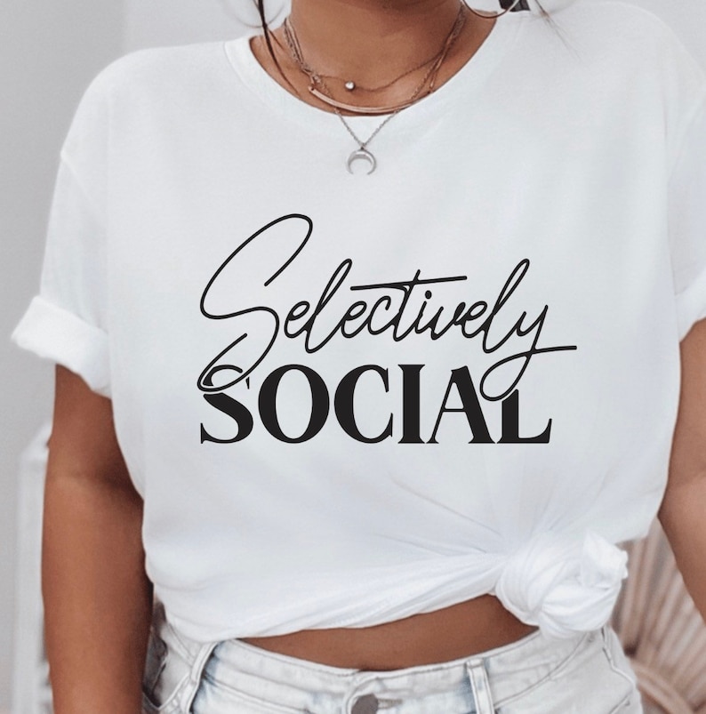 May include: White t-shirt with black text that reads "Selectively Social".