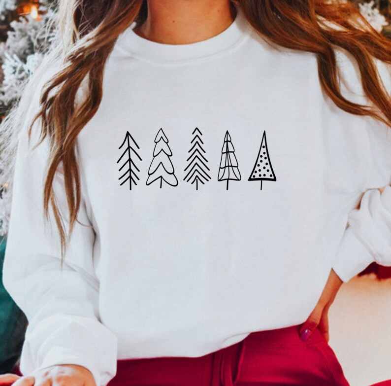 May include: White sweatshirt with a black graphic of five stylized Christmas trees.