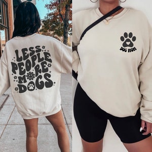 May include: A cream colored sweatshirt with the text "Less People More Dogs" in black on the back. The front of the sweatshirt has a black paw print with a heart in the center and the text "Dog Mom" underneath.