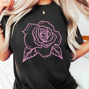 May include: Black t-shirt with a pink outline of a rose.