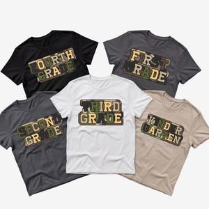 May include: Five short-sleeved t-shirts in black, dark grey, white, and tan. Each shirt features a rectangular camo-patterned graphic with text: Fourth Grade, First Grade, Second Grade, Third Grade, and Kindergarten in block lettering.