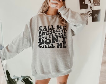 Puede incluir: Sudadera gris con texto negro que dice "Call me antisocial but please don't call me".