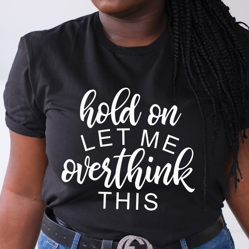 May include: Black t-shirt with white text that reads "hold on let me overthink this".