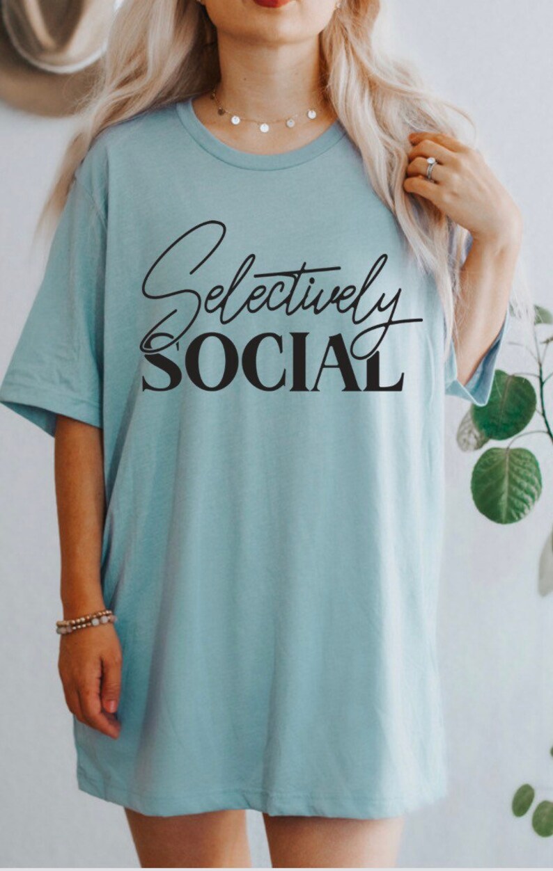 May include: A light blue t-shirt with the text "Selectively Social" printed in black.