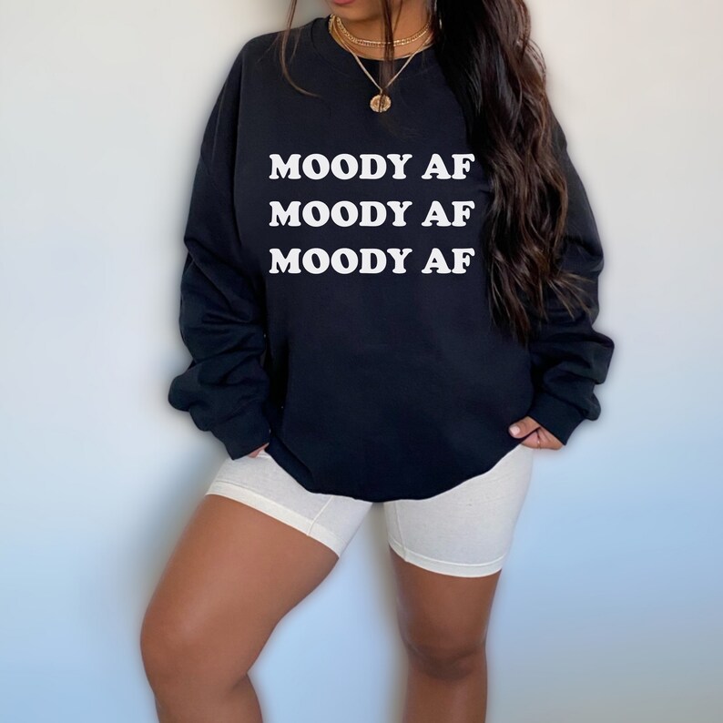 May include: Black sweatshirt with the text "MOODY AF" repeated three times in white.