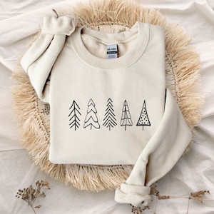 May include: A cream-colored sweatshirt with a black graphic of five stylized Christmas trees.