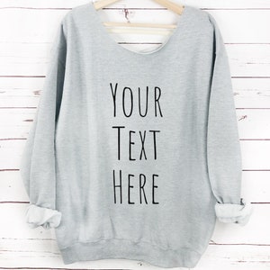 May include: Gray sweatshirt with a crew neck and long sleeves. The sweatshirt has a distressed back and the text "YOUR TEXT HERE" printed on the front.