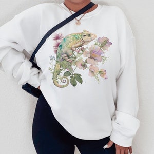 May include: White sweatshirt with a green chameleon and pink flowers printed on the front.