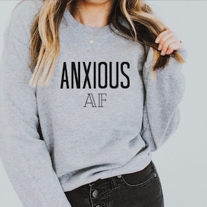 May include: Gray sweatshirt with the text "ANXIOUS AF" printed in black.