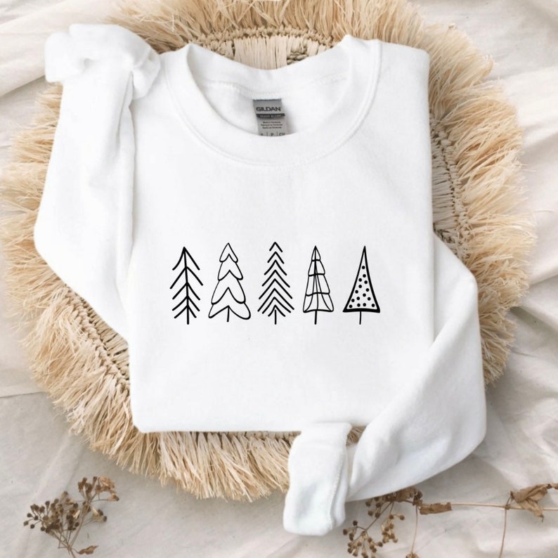 May include: White sweatshirt with a black graphic of five stylized Christmas trees.