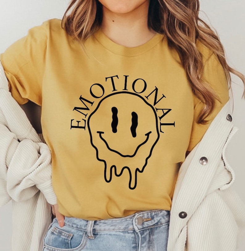 May include: A yellow t-shirt with a black dripping smiley face and the word "EMOTIONAL" around it.