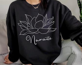 May include: Black sweatshirt with a white outline of a lotus flower and the word "Namaste" printed on the front.