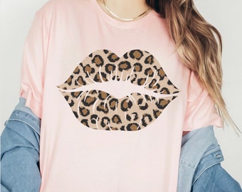 May include: A pink t-shirt featuring a large leopard print lips design.