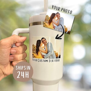 May include: A white insulated tumbler with a handle, featuring two photographs of a couple. The text "YOUR PHOTO" and "YOUR CUSTOM TEXT HERE" are visible. The tumbler has a white lid and a straw.