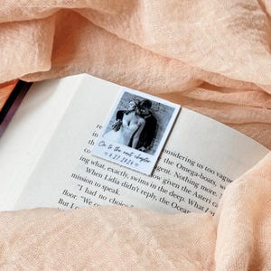 Custom polaroid bookmark in use between pages, hand-edited image and neat caption line.