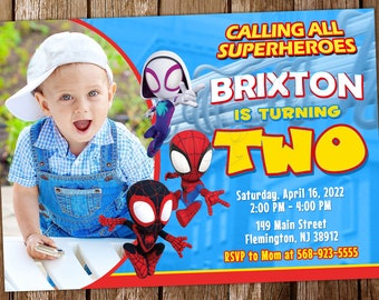 Può includere: Un invito di compleanno blu e rosso con una foto di un bambino piccolo che indossa un berretto da baseball bianco e una salopette di jeans blu. L'invito dice "Calling all superheroes, Brixton is turning two" e include la data, l'ora e il luogo della festa.