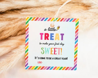 Peut inclure: Une étiquette cadeau carrée avec une bordure rayée colorée. Le texte "a little TREAT to make your first day SWEET!" est affiché en plusieurs couleurs. On peut également lire "IT'S GOING TO BE A GREAT YEAR!" et "LOVE-".