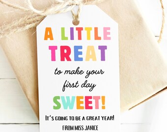 Peut inclure: Une étiquette cadeau blanche avec du texte coloré qui dit "A LITTLE TREAT to make your first day SWEET!" It's going to be a great year! From Miss Janice.