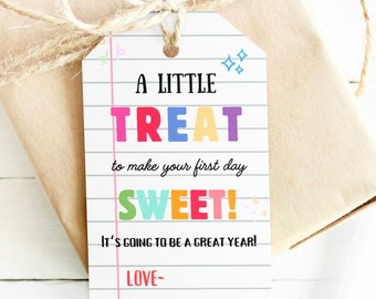 Peut inclure: Une étiquette cadeau blanche avec un fond rayé noir et blanc. Le texte sur l'étiquette dit "A LITTLE TREAT to make your first day SWEET! IT'S GOING TO BE A GREAT YEAR! LOVE-"