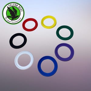 Può includere: Una collezione di guarnizioni circolari in gomma colorate in rosso, giallo, verde, viola, blu, bianco e nero. L'immagine include anche un logo con la scritta "FALCON NEST" e un uccello verde.