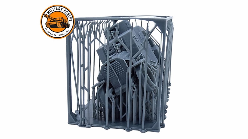 May include: A gray 3D printed model of a tank inside a gray 3D printed cage. The cage is made of a series of vertical and horizontal bars. The tank is partially visible through the bars. The image is labeled "Military Scales by 3D-RAP Technology".