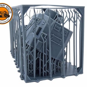May include: A gray 3D printed model of a tank inside a support structure. The structure is made of thin, vertical bars. The tank is tilted at an angle. The model is printed in a light gray color.