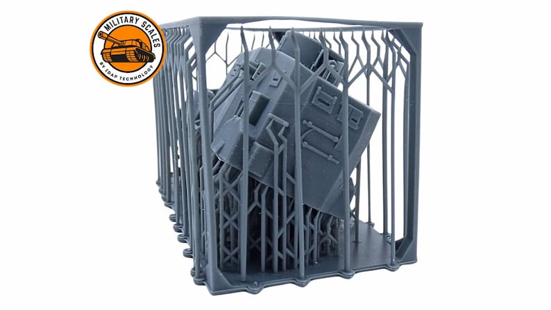 May include: A gray 3D printed model of a tank inside a support structure. The structure is made of thin, vertical bars. The tank is tilted at an angle. The model is printed in a light gray color.