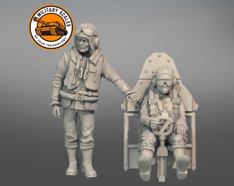 Könnte beinhalten: Zwei graue Plastikfiguren von Piloten, eine steht und die andere sitzt in einem Cockpit. Der stehende Pilot trägt einen Fluganzug und einen Helm. Der sitzende Pilot trägt einen Fluganzug, einen Helm und einen Fallschirm. Die Figuren sind Teil eines Modellbausatzes.