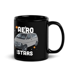 May include: Black coffee mug featuring a white graphic of a grey minivan with the text "Aero in the Stars" on a black background.