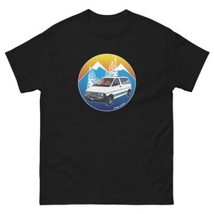 May include: A black t-shirt featuring a white van in a circular graphic. The van is set against a mountain range with a sunset behind it. The text "1989 Journey" is positioned below the van.
