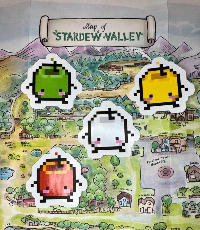 May include: A selection of pixelated fruit stickers in green, yellow, white, and red, each with a friendly face. They are placed on a map of Stardew Valley, a watercolour illustration showing various locations.