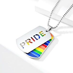 May include: A silver necklace with a dog tag pendant that says "PRIDE" in rainbow colors. The dog tag is double-sided, with a rainbow design on the back.
