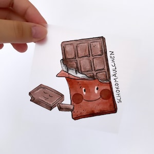 May include: A watercolor illustration of a chocolate bar with a smiling face. The chocolate bar is broken in half, with one piece lying on the ground. The text "SCHOKOMÄULCHEN" is written on the side of the chocolate bar.
