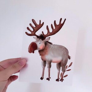 Può includere: Un'illustrazione ad acquerello di un alce dei cartoni animati con grandi corna. L'alce è in piedi su uno sfondo bianco con alcune foglie marroni.