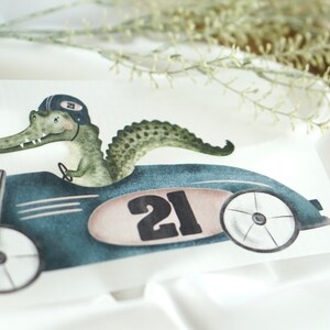 May include: A green alligator wearing a racing helmet drives a blue vintage race car with the number 21 on the side.