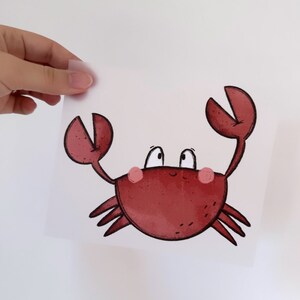 Può includere: Un'illustrazione di un granchio rosso con occhi grandi e un sorriso. Il granchio ha due grandi chele e otto zampe.