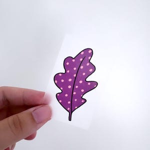 May include: A purple leaf with pink polka dots. The leaf is outlined in black.