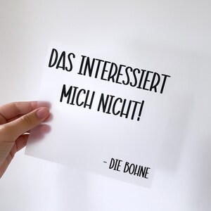 Può includere: Un biglietto bianco con testo nero che dice "Das interessiert mich nicht! - Die Bohne".