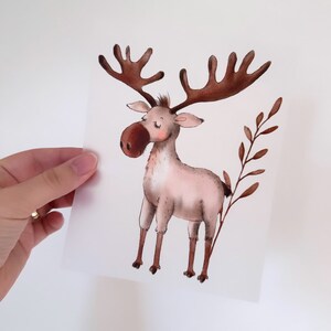 Può includere: Un'illustrazione ad acquerello di un alce marrone e bianco con grandi corna. L'alce è in piedi su uno sfondo bianco con un ramo marrone dietro.